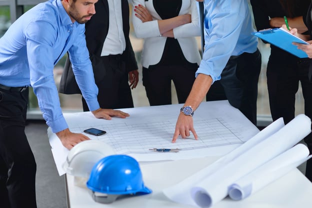 business people group on meeting and presentation in bright modern office with construction engineer architect and worker looking building model and blueprint plans